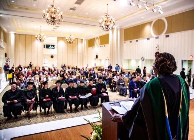 The MC looks out to the crowd of the graduates and their families.